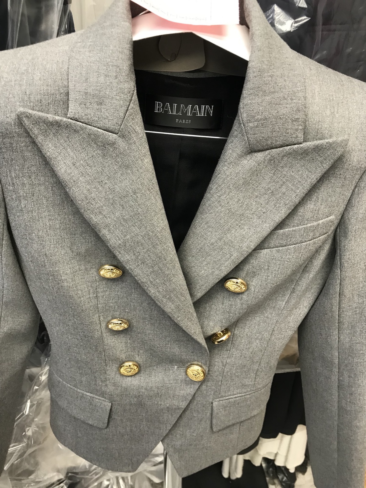 Grey wool blazer with gold buttons, cleaned and hung in the shop