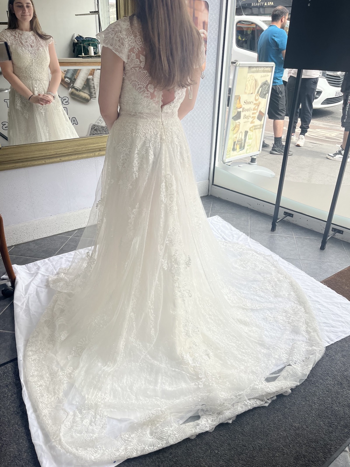 A lace wedding dress laid out on a clean sheet inside the Fresh Touch shop