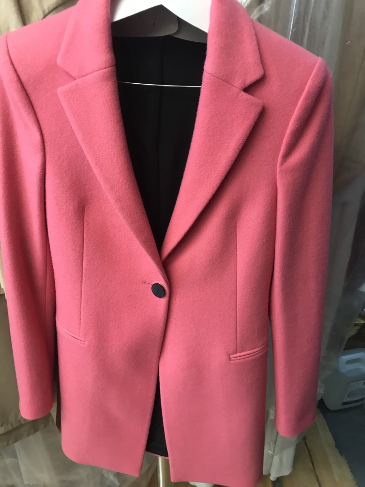 Pink wool coat finished and hung ready for collection